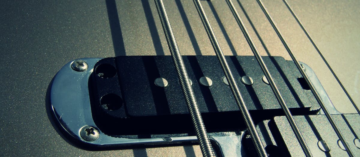 Detailed view of guitar strings and pickups highlighting texture and design.